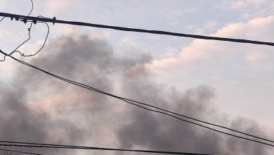Fum dens deasupra orașului provenind de la un incendiu la un service auto