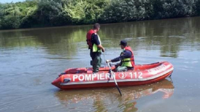 Pompieri cautând o persoană dispărută în apele unui râu